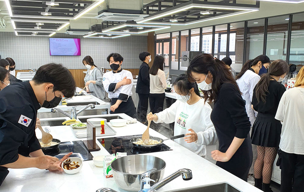 영진전문대학교에 재학 중인 외국인 유학생들이 내국인 학생들의 도움을 받아 K-푸드 한식 체험을 하고 있다.