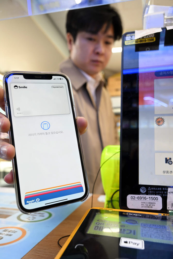 애플의 근거리무선통신(NFC) 간편결제 서비스 애플페이가 국내 공식 출시했다. 21일 서울 한 편의점에서 본지 기자가 현대카드가 등록된 애플페이로 결제를 하고 있다. 김민수기자 mskim@etnews.com