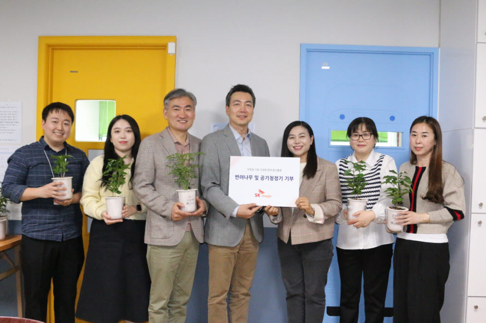 SK매직 임직원이 식목일 주간을 맞아 반려나무와 친환경 가전을 경기도 화성지역아동센터에 전달했다. 왼쪽 세번째부터 윤학진 SK매직 화성공장장, 윤요섭 SK매직 대표, 김화순 매송지역아동센터장.