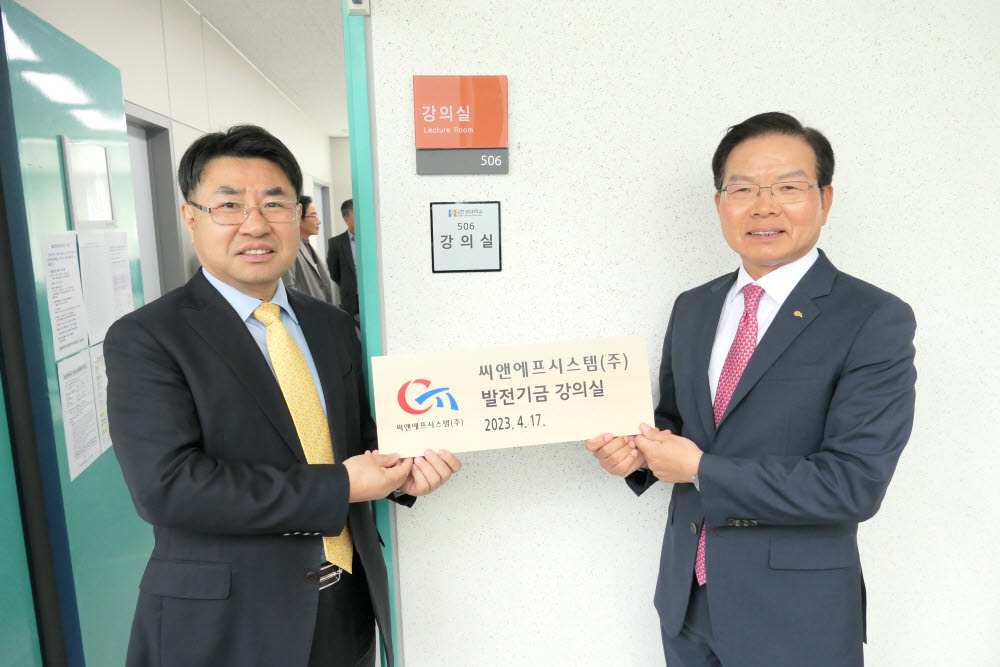 박정수 씨앤에프시스템 대표(오른쪽)와 이원희 한경국립대 학술장학진흥재단 이사장이 한경국립대학교 PBL 강의실 기부자 명패를 들고 기념촬영했다. 씨앤에프시스템 제공