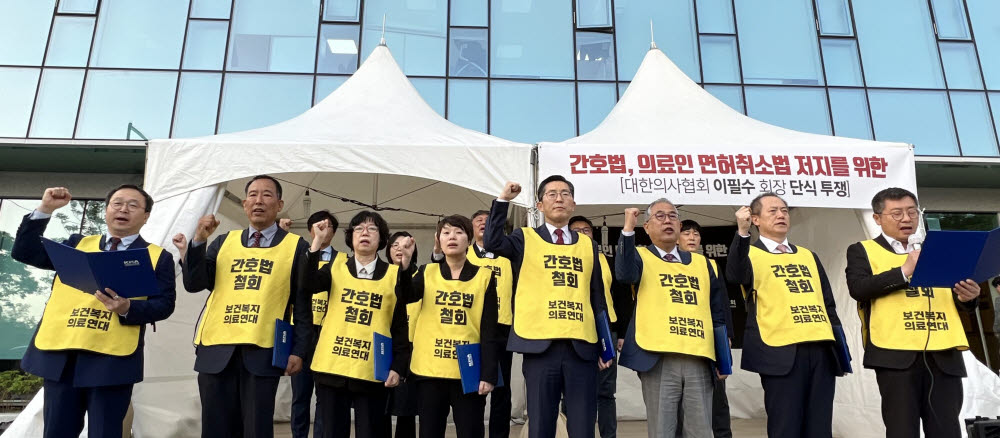 대한의사협회와 대한간호조무사협회 등 13개 보건의료단체가 구성한 보건복지의료연대 관계자들이 지난달 27일 오후 서울 용산구 대한의사협회 앞에서 국회 본회의 간호법 통과 뒤 입장문을 발표하고 구호를 외치고 있다. <출처=연합뉴스>